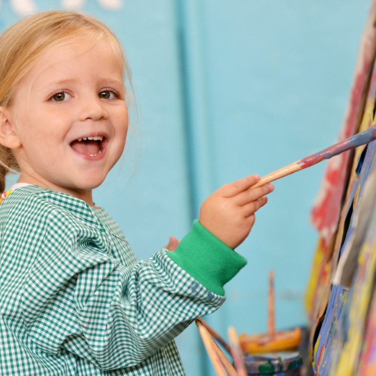 child smiling and painting